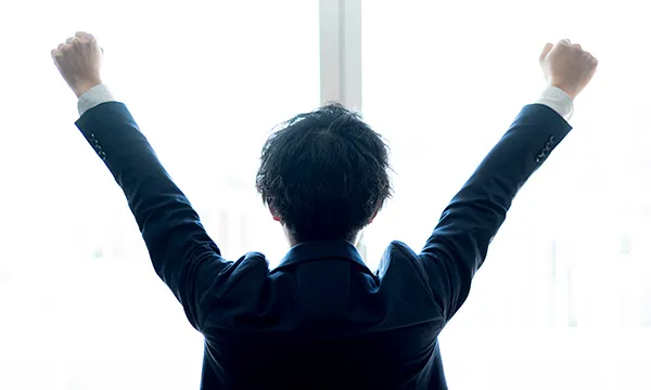 ガッツポーズの男性スタッフのの背中の写真