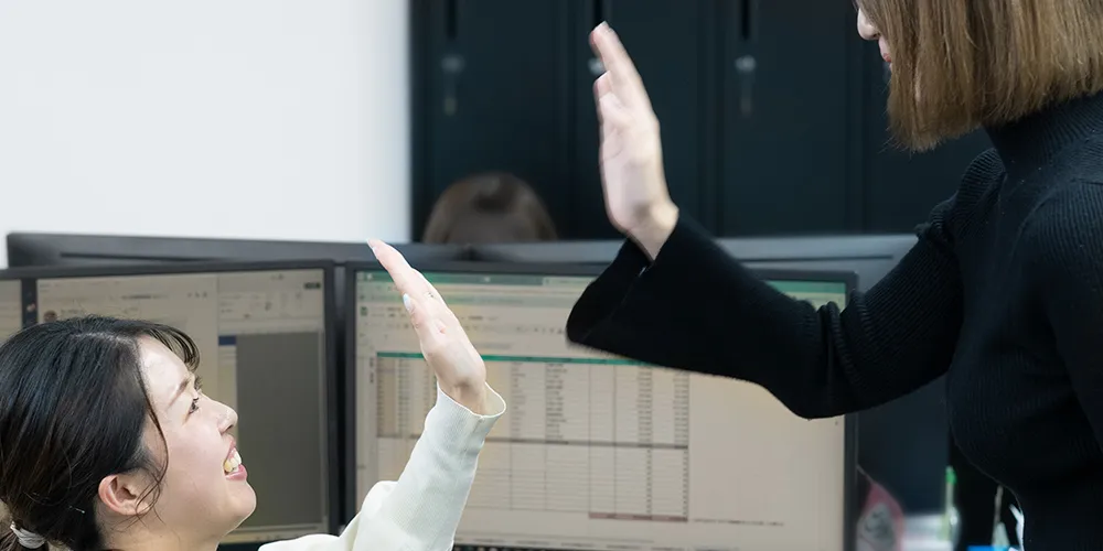 ハイタッチをする女性スタッフ二人の写真